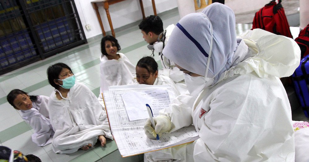 A nurse assisting school children in the Pasir Gudang area.