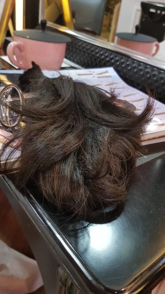 Tie your hair into a ponytail and cut it just above the rubber band