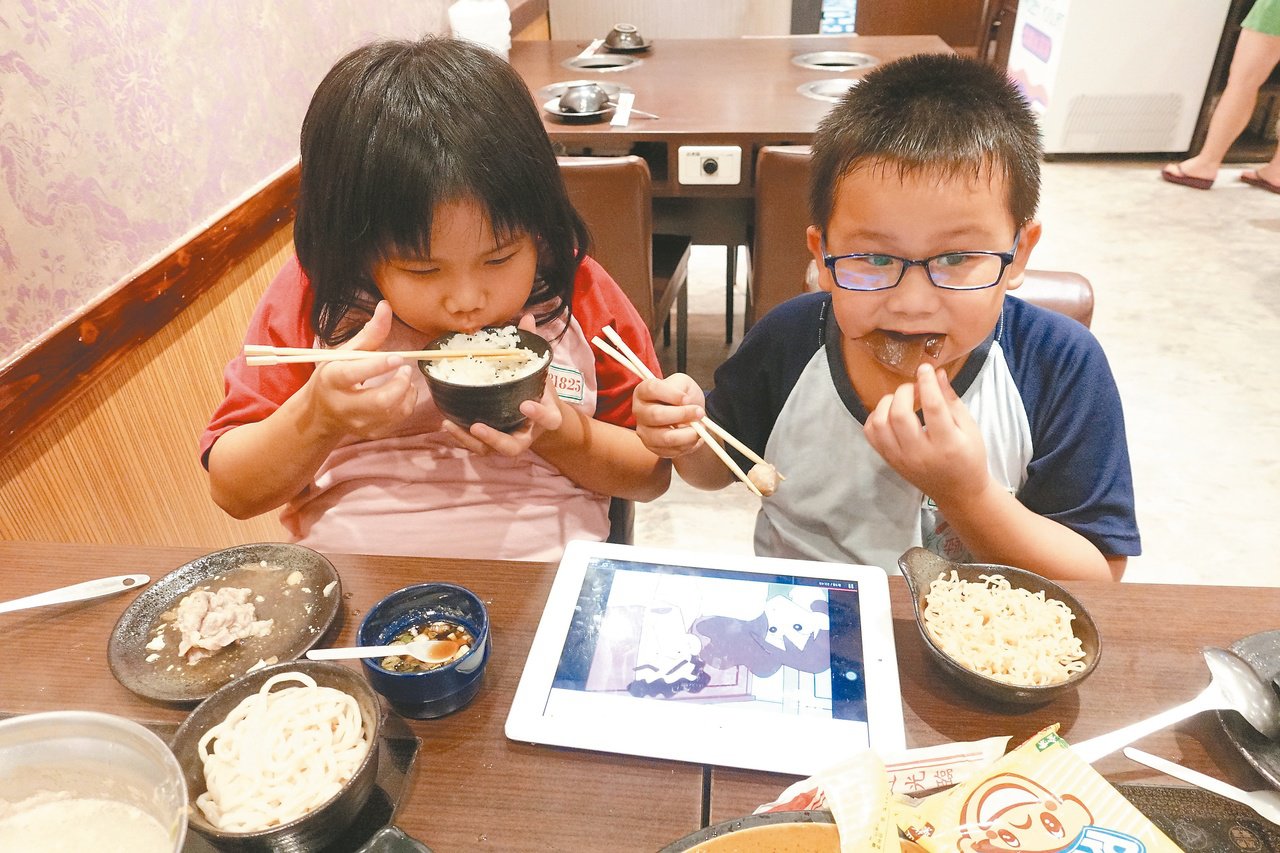 小朋友边吃饭吃看手机