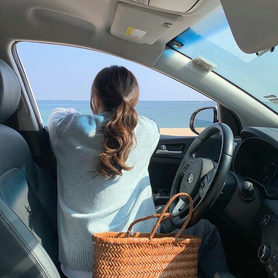 女生坐在车里面看海